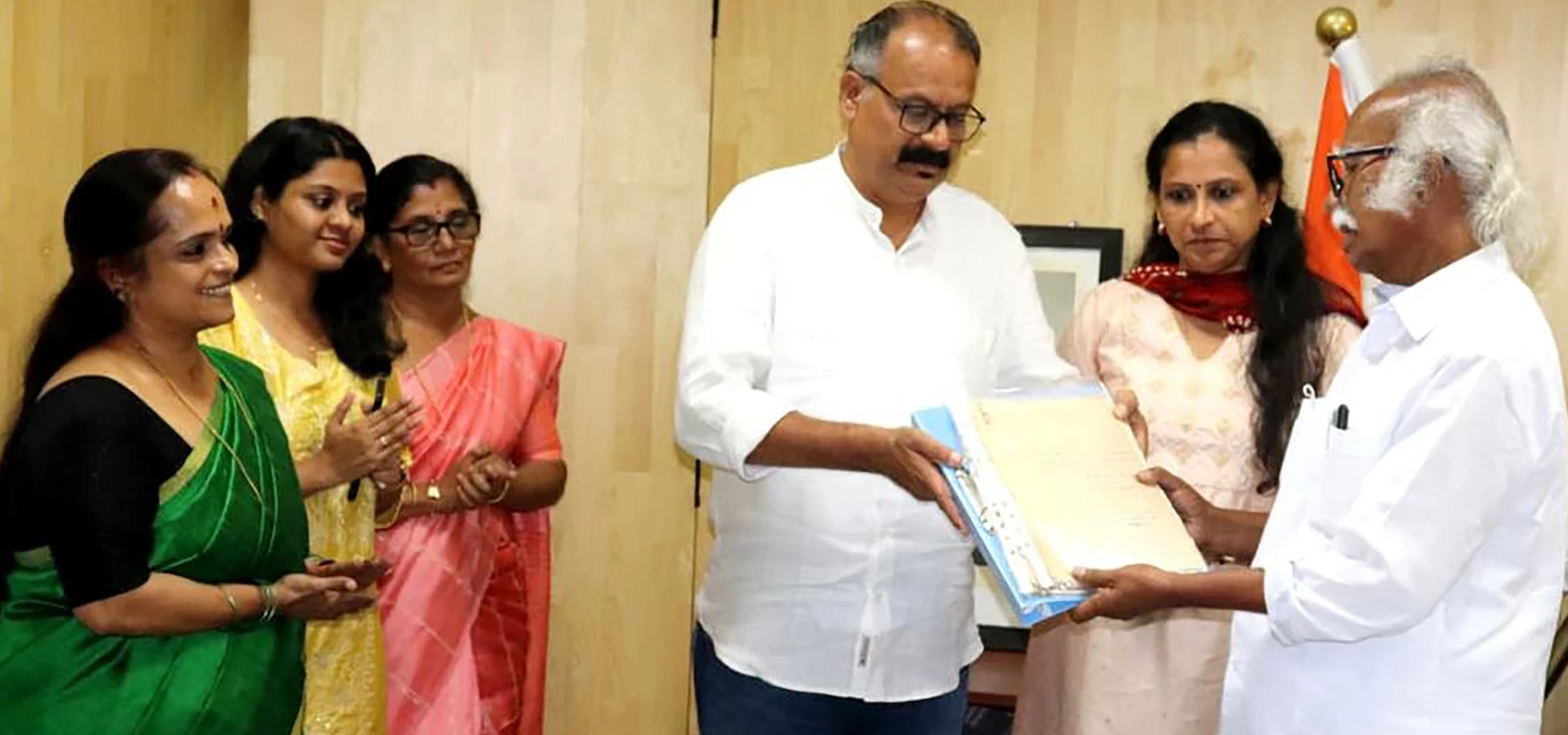 Minister Kadannappally Ramachandran receives manuscripts of Veloor Krishnankutty from his children, Vinod and Kalavinodini